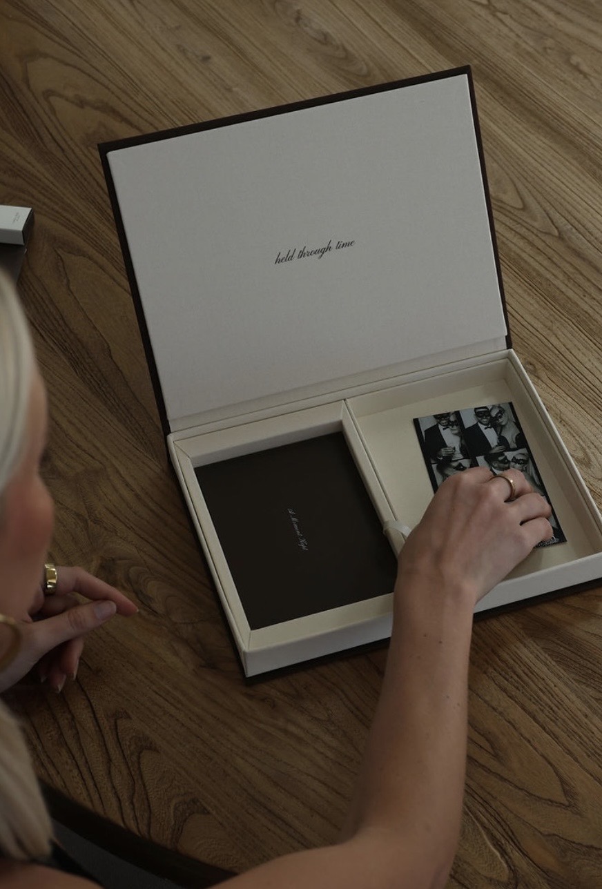 A hand lifting the lid of the Poetic Romance keepsake box, held through time