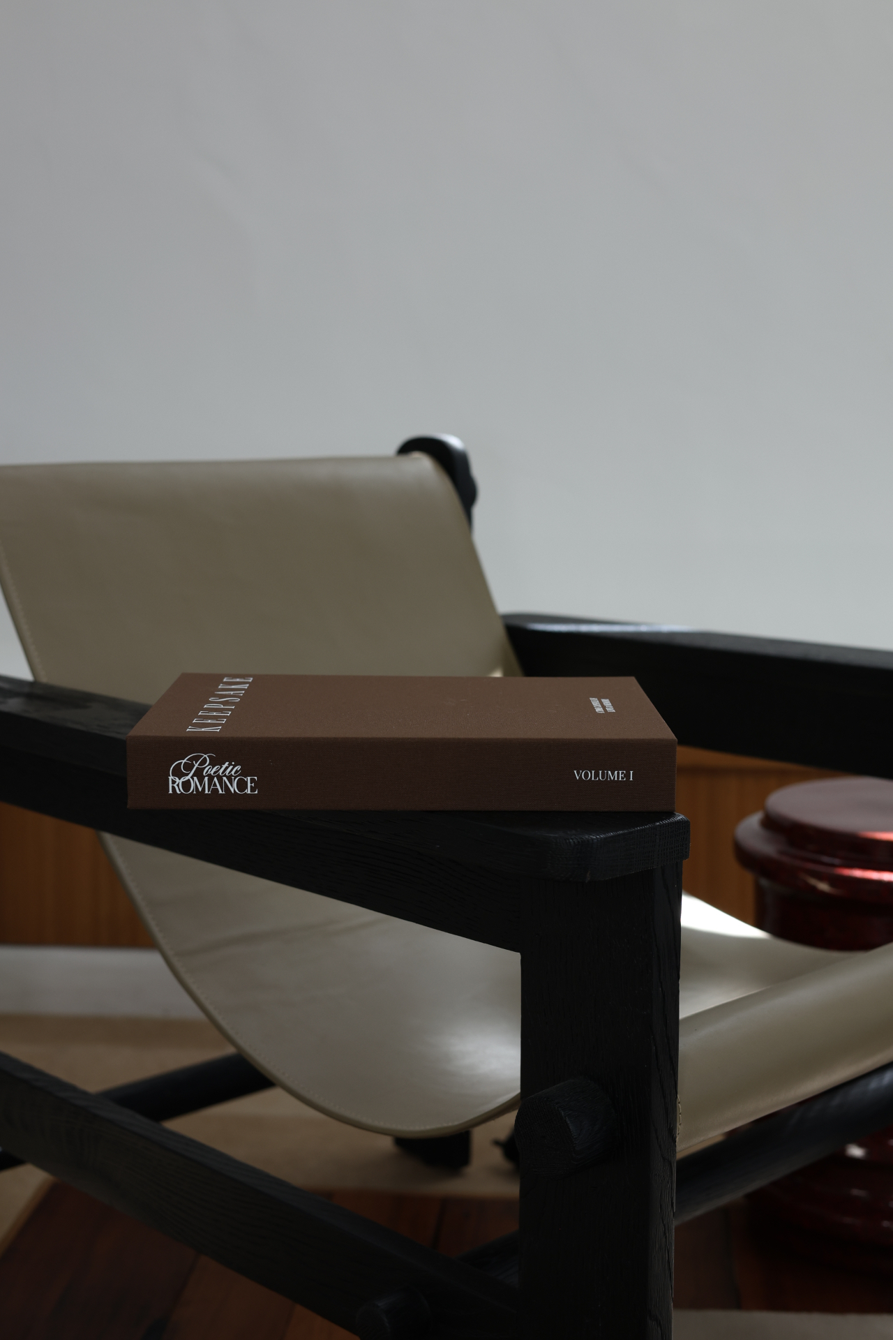 Poetic Romance Keepsake Volume One resting on a modern lounge chair
